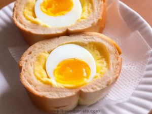 tamago sando japanese egg sandwich with a whole hard boiled egg in the centre.