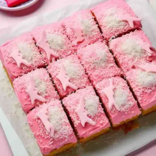 Mary Berry's Tottenham Cake with pink icing and coconut topping on a white plate