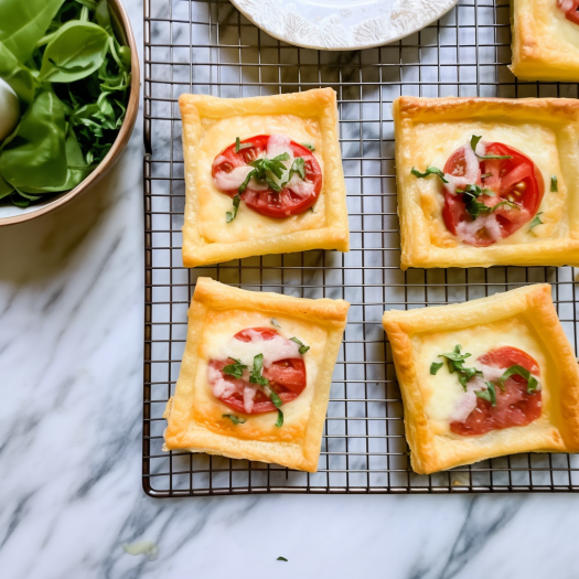 Puff Pastry Squares with a slice of tomato each, basil, and a mix of cheese.