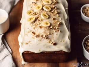 Mary Berry banana laof cake with cream cheese icing and topped with cinnamon and slices of bananas