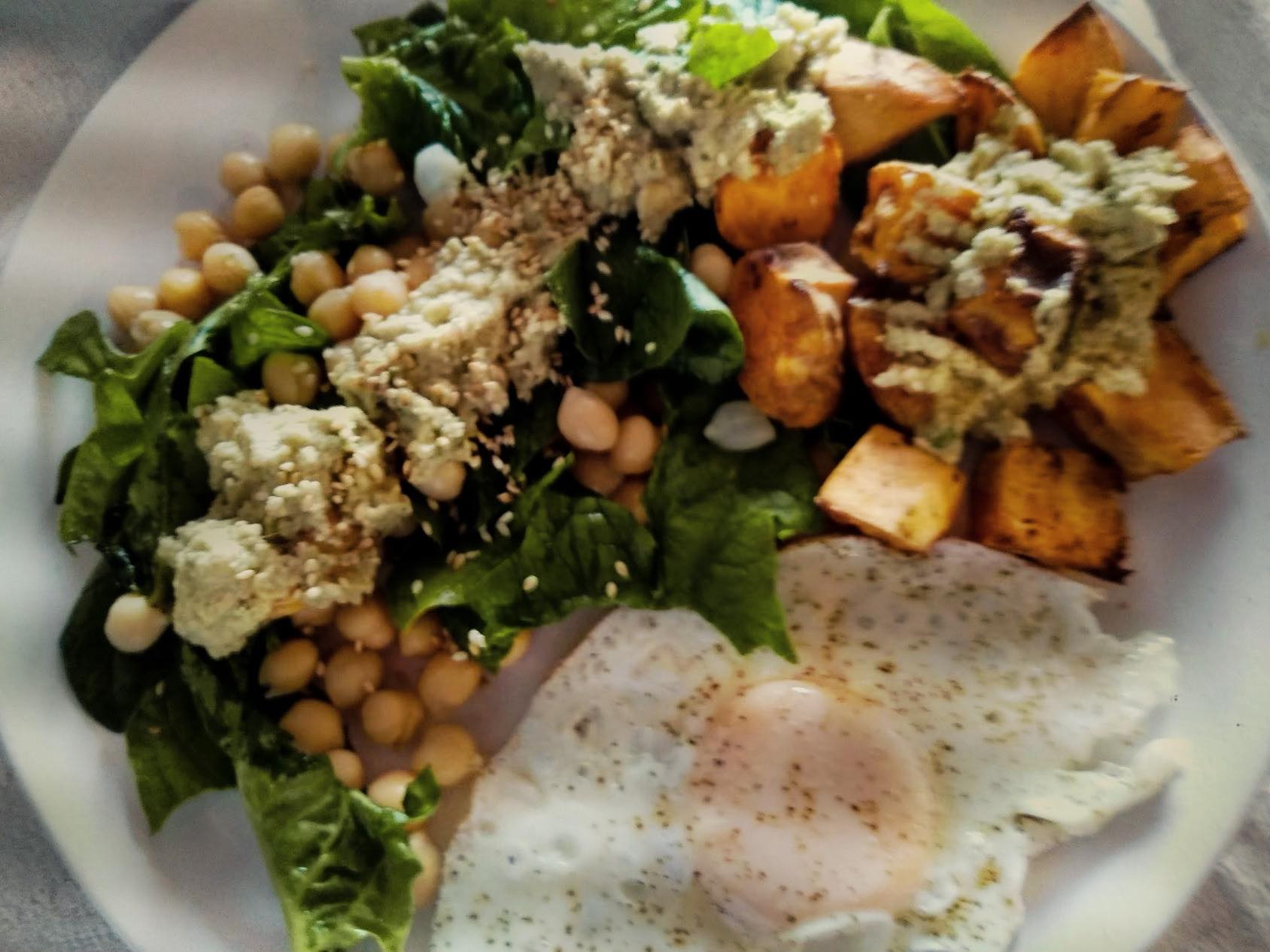 chickpeas, kale, potatoes, sesame seeds served with a fried egg