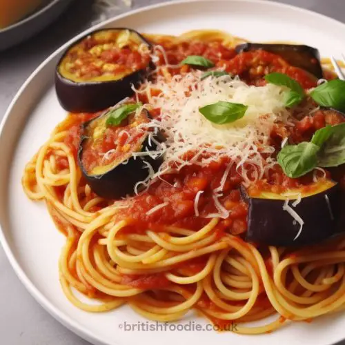 eggplant pasta alla norma topped with parmesan and basil leaves