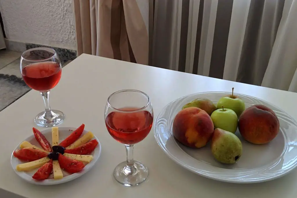 Wine glasses and a small plate with fruits and cheese